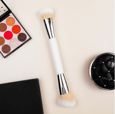 Makeup brushes and cosmetics on a light background.