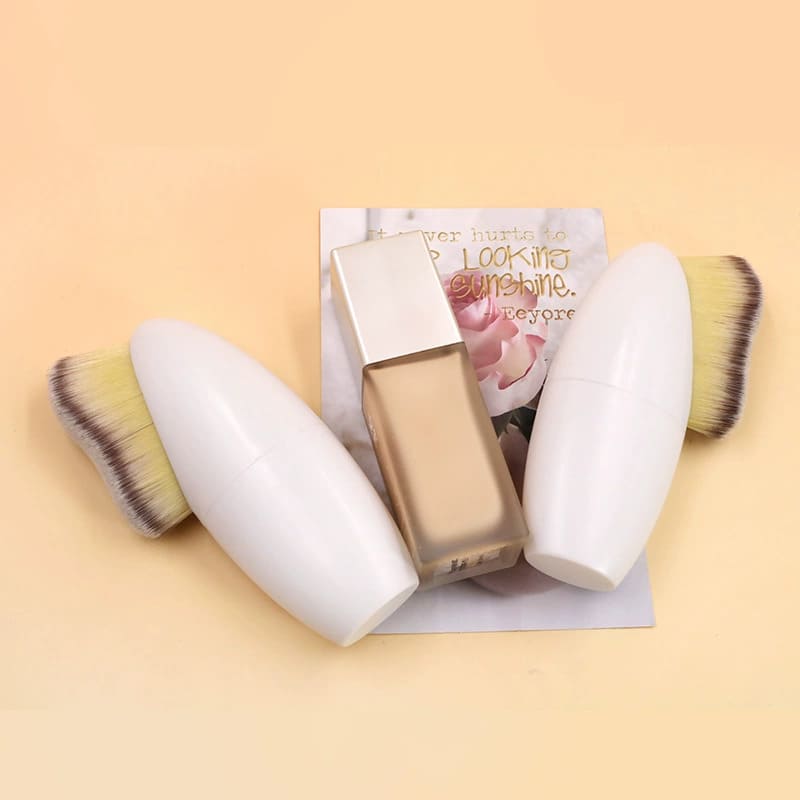 Flacon de fond de teint avec deux pinceaux applicateurs ovales et une carte de motivation.