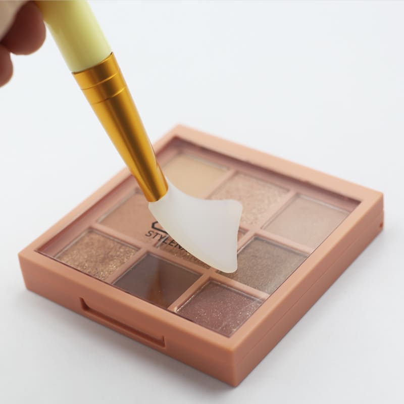 Peach eyeshadow palette being applied with a silicone spatula brush.