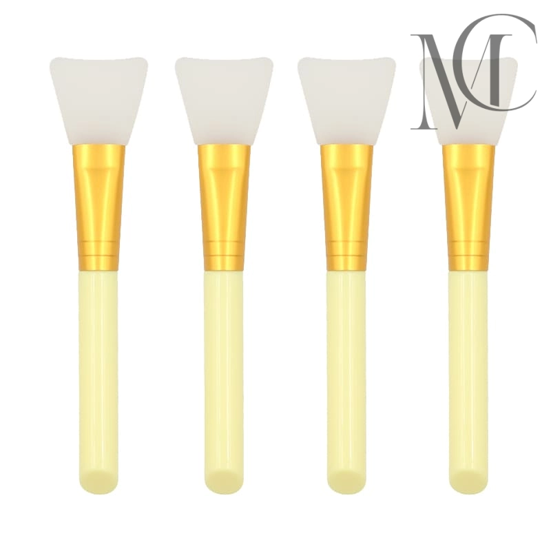 Brocha para aplicar mascarilla facial Cuatro pinceles aplicadores de mascarillas faciales de silicona con mangos dorados y tallos de color crema.