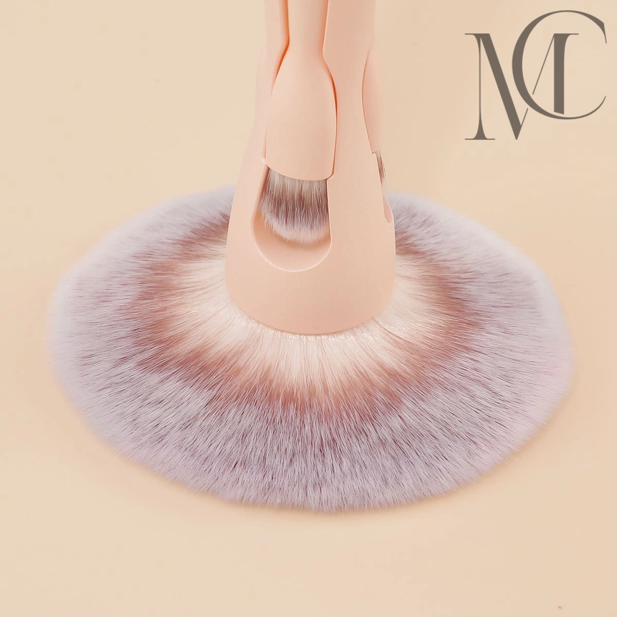 Detachable dual-purpose brush Close-up of a large makeup brush with light pink handle and white-tipped purple bristles.