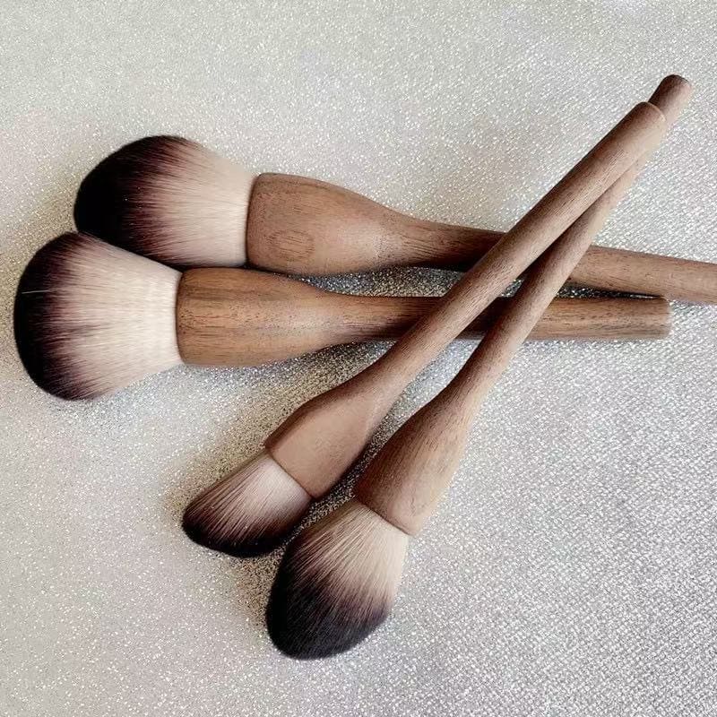 Makeup brushes with wooden handles and gradient bristles.