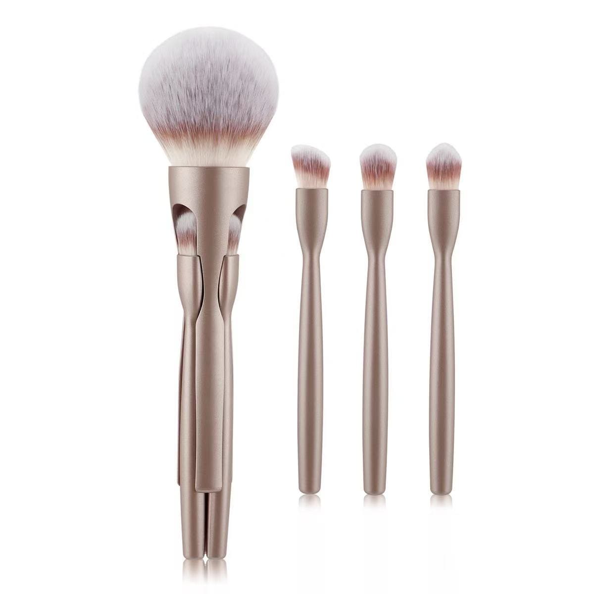 Set of four gold-handled makeup brushes with white and brown bristles.