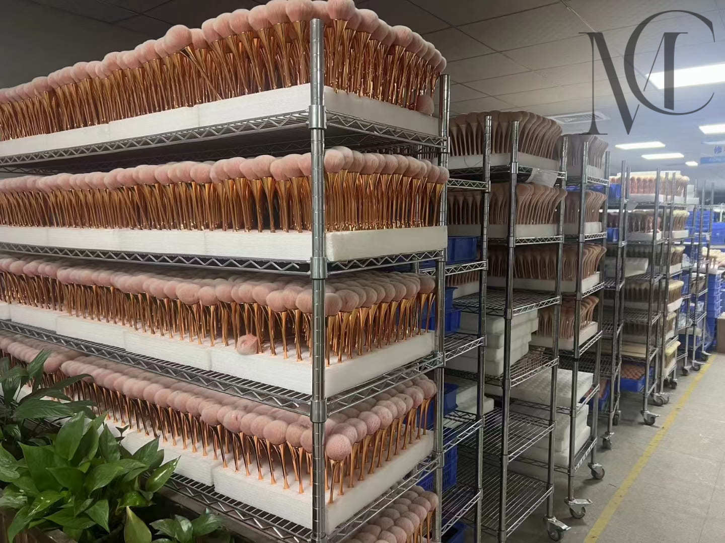 Makeup brush factory Shelving racks filled with rows of pink and gold makeup brushes in a factory.