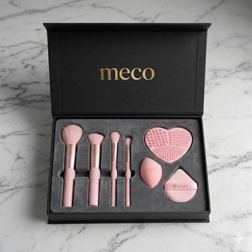 Meco makeup brush set with pink brushes, heart-shaped cleaner, and sponges in a black box.