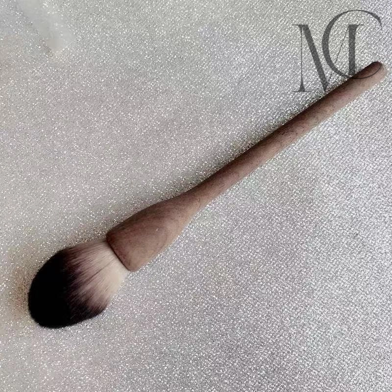 One-piece molded wooden brush Makeup brush with a wooden handle on a glittery surface.