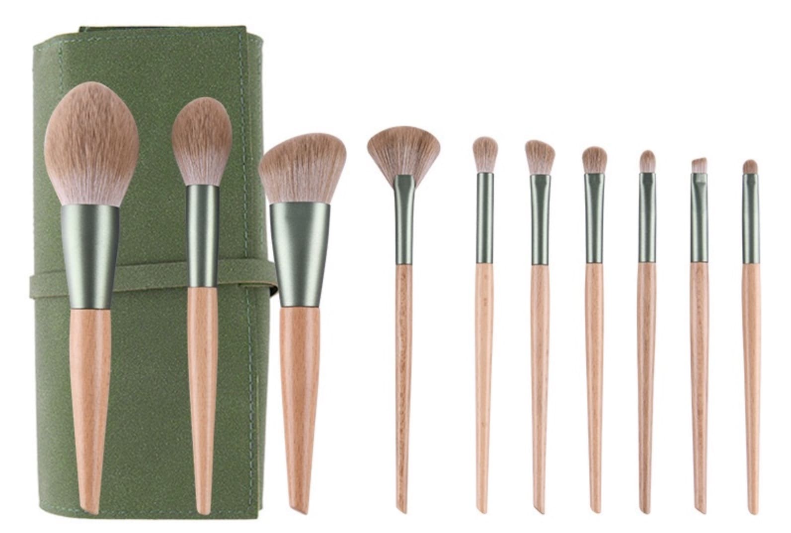 Makeup brush set with wooden handles and green carrying case.