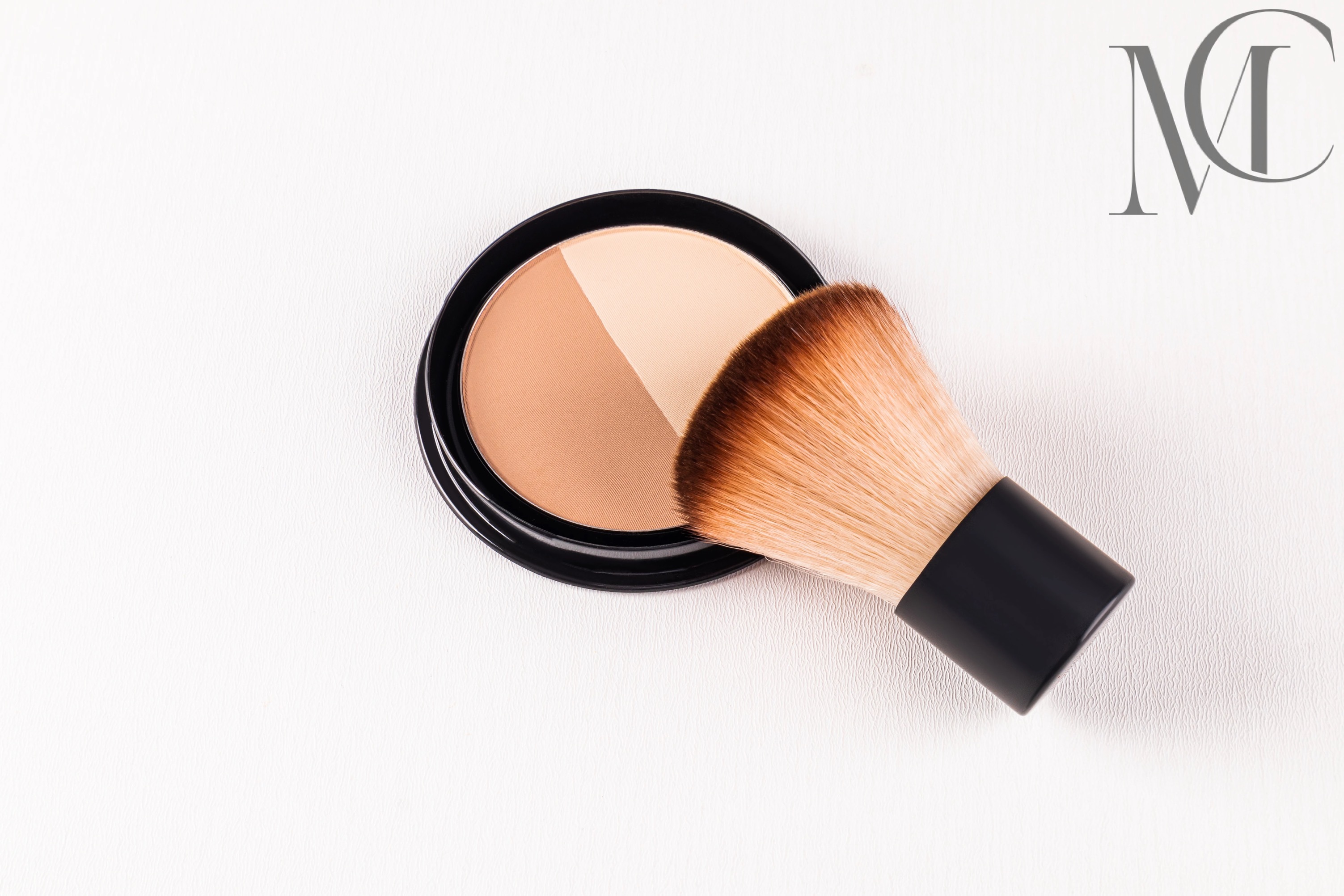 Fabrication de mini pinceaux à fond de teint Boîtier de maquillage avec deux teintes et un pinceau à poudre sur fond blanc.