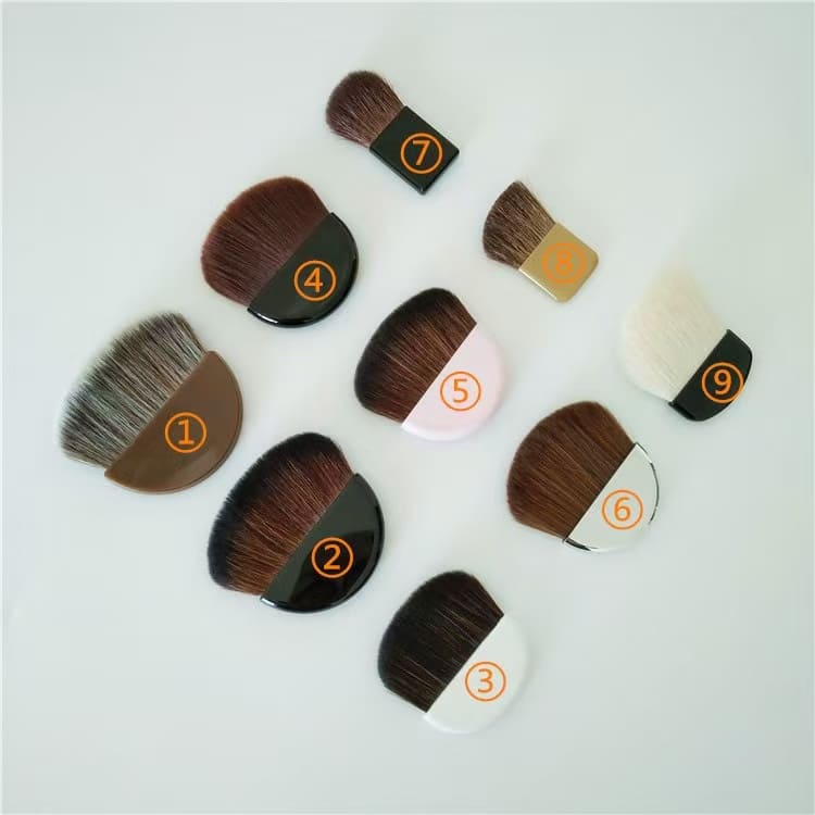 Nine numbered kabuki makeup brushes on a white surface.