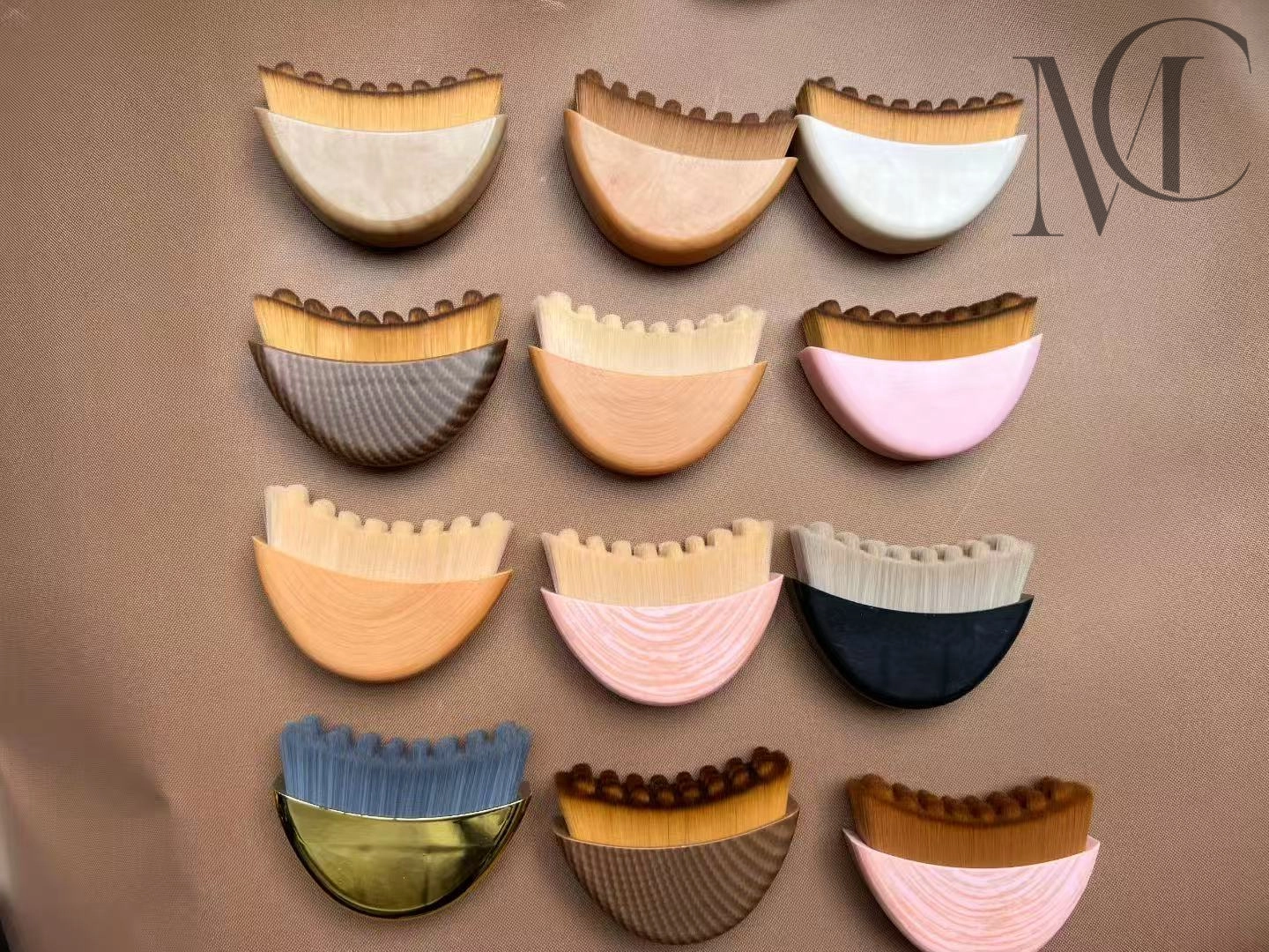 Cepillo facial de contorno linfático popular Doce pinceles de maquillaje coloridos y únicos dispuestos sobre una superficie marrón.