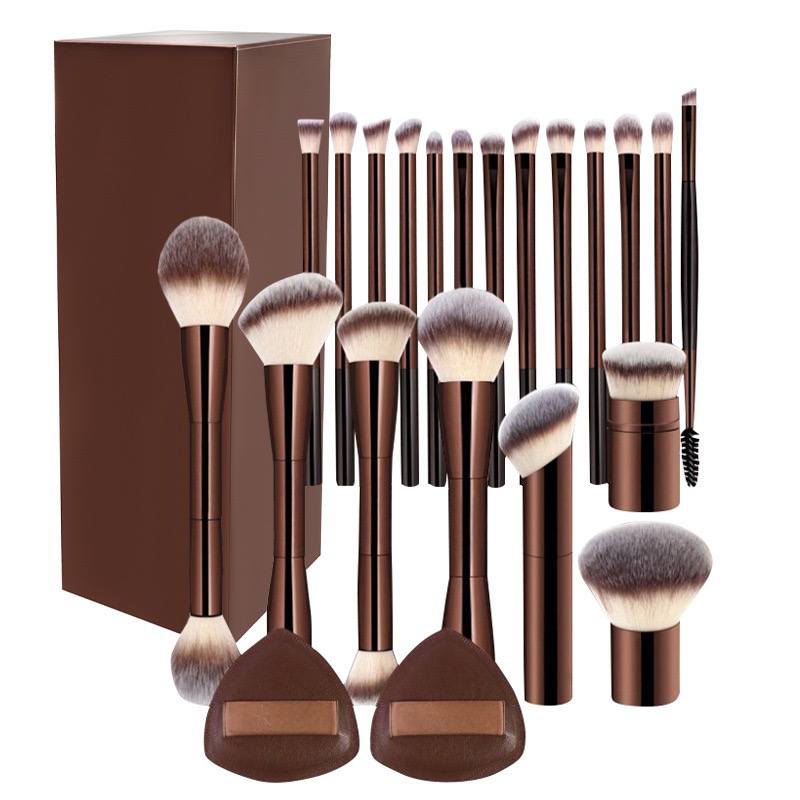 A collection of brown makeup brushes and sponges in various sizes, with a brown box in the background.