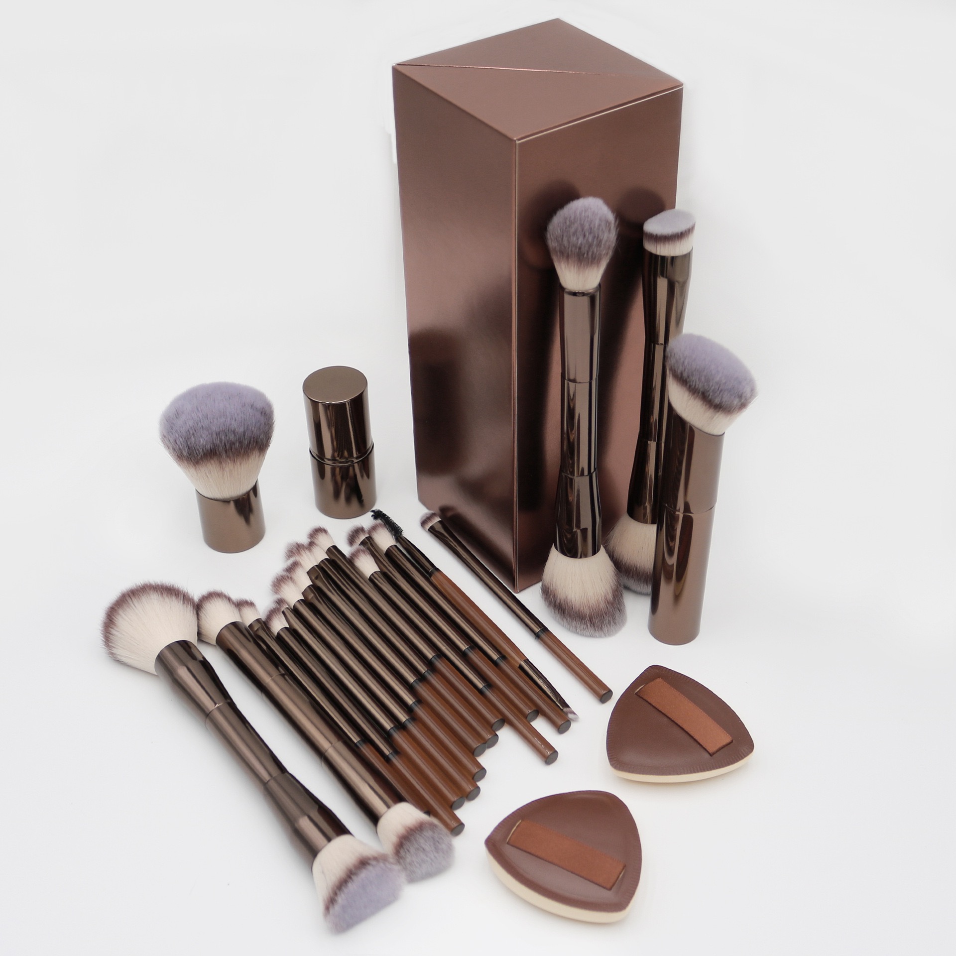 Makeup brush set with brown handles, soft bristles, a matching box, and two makeup sponges.