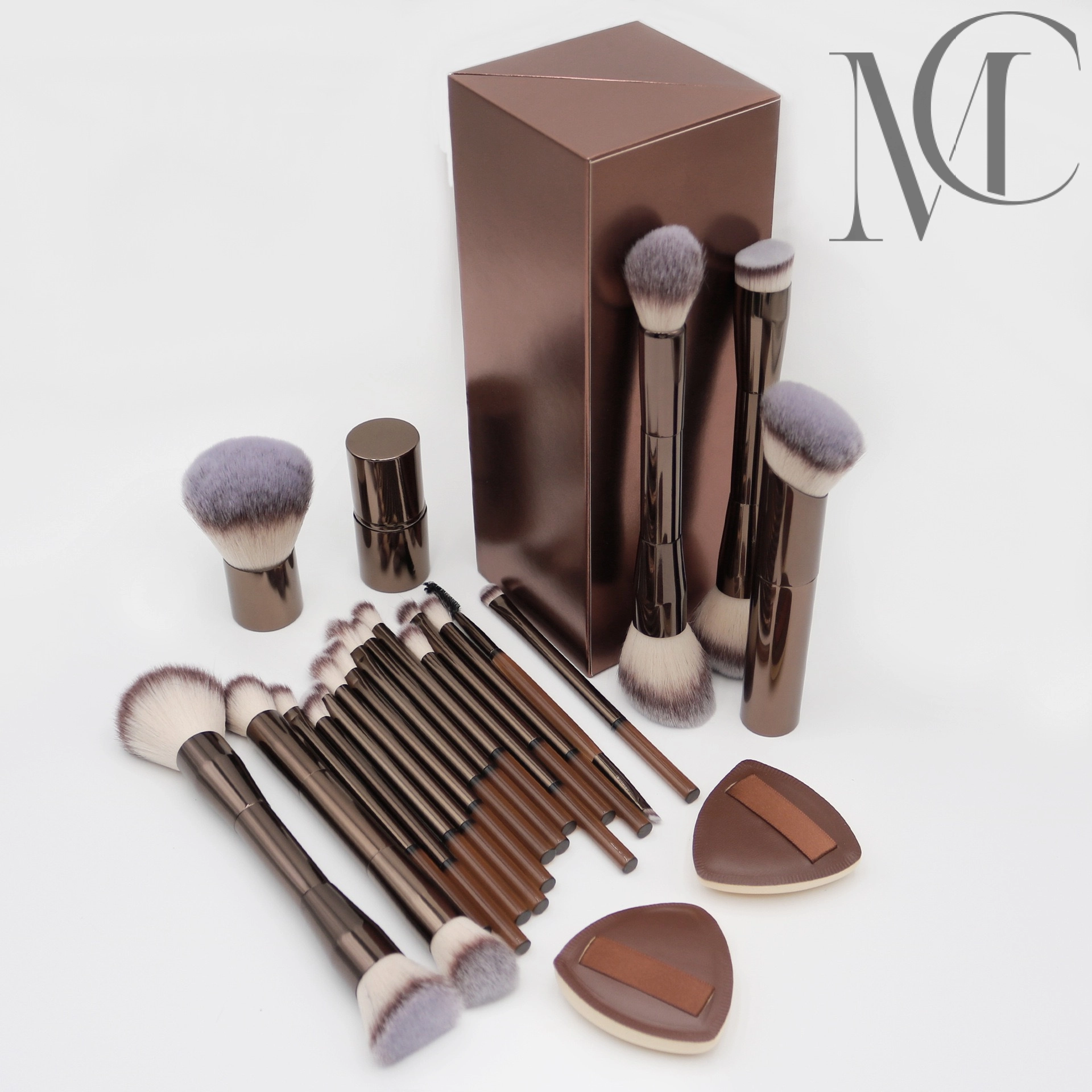 cruelty-free makeup brush manufacturer Makeup brush set with brown handles, soft bristles, a matching box, and two makeup sponges.