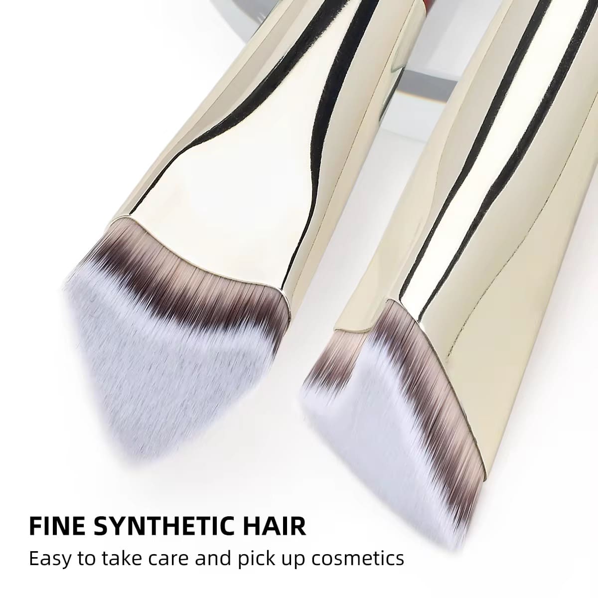 Two gold-handled makeup brushes with soft, angled synthetic bristles, one in focus.