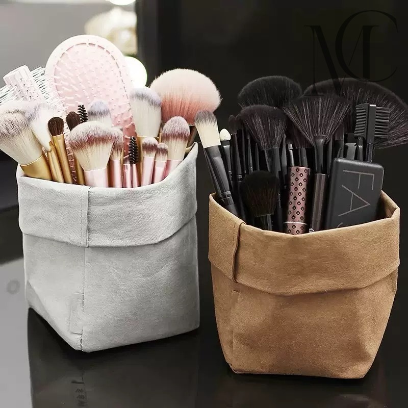 Juego de pinceles para embalaje de papel Dos estuches de tela para brochas de maquillaje, uno gris con brochas rosas y otro marrón con brochas oscuras.