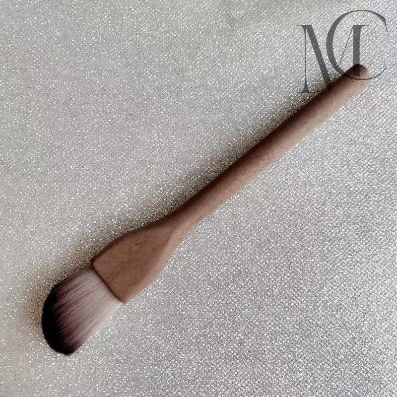 Wooden eco-friendly makeup brush Makeup brush with wooden handle on a glittery surface.